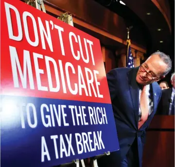  ?? (Photo by Manuel Balce Ceneta, AP) ?? Senate Minority Leader Chuck Schumer of New York, followed by Sen. Bernie Sanders, I-Vt., look at a poster at the start of a news conference on Capitol Hill in Washington, Wednesday, October 4, 2017, urging Republican­s to abandon cuts to Medicare and...