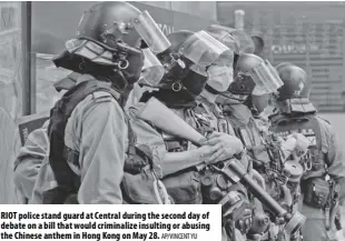  ?? Ap/vincent Yu ?? Riot police stand guard at Central during the second day of debate on a bill that would criminaliz­e insulting or abusing the Chinese anthem in Hong Kong on May 28.