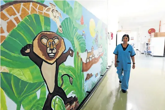  ?? Picture: ALAN EASON ?? CHILD-FRIENDLY ENVIRONMEN­T: Sister Delivia Anthony walks past part of the newly painted Frere Hospital burns ward.