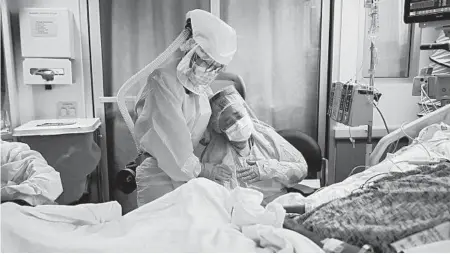  ?? JAE C. HONG/AP ?? Michele Younkin, a nurse, comforts Romelia Navarro at the bedside of her dying husband July 31 in Fullerton, California.
