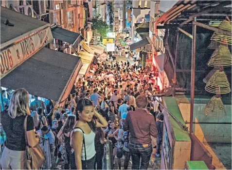  ??  ?? Revellers mass on the streets in Hong Kong’s traditiona­lly bustling Soho area after the island loosened curbs on social gatherings and reopened its schools
