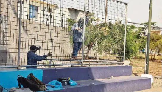  ?? ?? La tarde del pasado martes, dos obreros soldaban las vallas alrededor de una cancha deportiva en la zona. Con lo que se busca reforzar la seguridad de la zona.