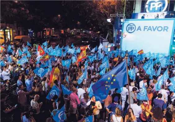  ?? AFP ?? Simpatizan­tes del Partido Popular (PP) ondean sus banderas mientras esperan los resultados de las elecciones en Madrid.