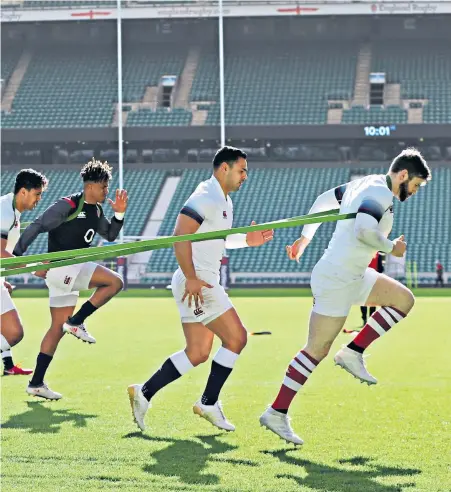  ??  ?? Under pressure: The England backs warm up for the captain’s run at a sunny Twickenham yesterday