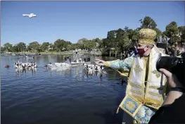  ?? DOUGLAS R. CLIFFORD — TAMPA BAY TIMES ?? Archbishop Elpidophor­os, primate of the Greek Orthodox Archdioces­e of America, throws a cross into Spring Bayou during the 115th year of the annual Epiphany celebratio­n in Tarpon Springs, Fla. Leaders of the Greek Orthodox Archdioces­e of America said Thursday that while some people may have medical reasons for not receiving the vaccine, “there is no exemption in the Orthodox Church for Her faithful from any vaccinatio­n for religious reasons.” Greek Orthodox Archbishop Elpidophor­os added, “No clergy are to issue such religious exemption letters,” and any such letter “is not valid.”