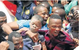  ?? Picture: TEMILADE ADELAJA/REUTERS ?? BROUGHT TO SAFETY: Men carry a boy who was rescued at the site of a collapsed building containing a school in Nigeria’s commercial capital of Lagos on Wednesday