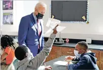  ?? MANUEL BALCE CENETA/ASSOCIATED PRESS ?? President Joe Biden stops to look at a student’s project as he tours Brookland Middle School on Friday in Washington. Biden has encouraged every school district to promote vaccines, including with on-site clinics, to protect students as they return to school amid a resurgence of the coronaviru­s.