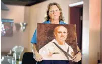  ?? MIKE STOCKER /SUN SENTINEL ?? Debbi Hixon holds a painting of her husband Chris Hixon. The athletic director and wrestling coach at Marjory Stoneman Douglas High was killed in the Parkland school shooting.