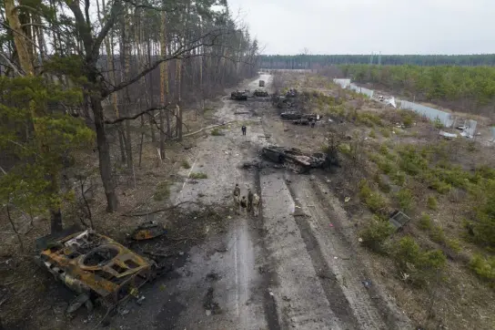  ?? Rodrigo Abd, The Associated Press ?? Ukrainian soldiers stand amid destroyed Russian armor vehicles Thursday on the outskirts of Kyiv.