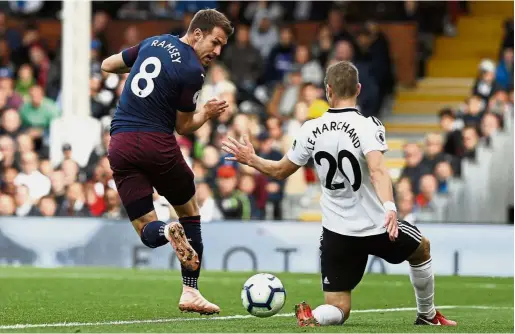  ?? — AFP ?? A little backheel and voila!: Arsenal’s Aaron Ramsey (left) scoring his side’s third goal during the Premier League match against Fulham at Craven Cottage on Sunday.