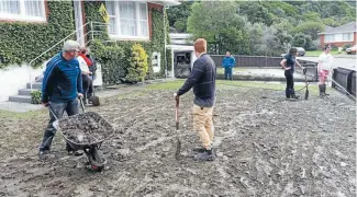  ??  ?? Members of the Wellington Volunteer Student Army help clean up a house in Rangituhi Crescent, Porirua that was blanketed with mud during Thursday’s flooding.