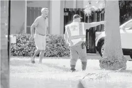  ?? MIKE STOCKER/SOUTH FLORIDA SUN SENTINEL ?? A Fort Lauderdale Public Works employee gives informatio­n to a resident regarding a sewage spill at Hector Park on Ponce De Leon Drive on Tuesday.