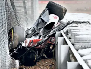  ?? AFP ?? Alfa Romeo Chinese driver Zhou Guanyu is seen inside the car wedged between the fence and the tyre barriers. His car skidded off across a gravel trap and over tyre barriers into the catch fencing, where it bounced back to finish semi-upright in a stationary position.