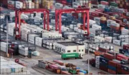  ?? FILE — THE ASSOCIATED PRESS ?? In this file photo, a cargo truck drives amid stacked shipping containers at the Yangshan port in Shanghai. China’s export growth sank in November, 2018, as global demand weakened, adding to pressure on Beijing ahead of trade talks with Washington.