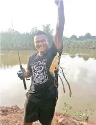  ??  ?? WESLEY dengan hasil udang galah yang dipancingn­ya di Sungai Muanad.