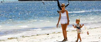  ?? —LYN RILLON ?? Foreigners enjoy a stroll on the white sand beach of Boracay Island in Aklan province.