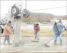  ?? Keith Bryant/The Weekly Vista ?? Juan Reveles, left, helps to guide the cement for the Razorback Greenway’s new spur alongside Cooper Elementary while Mario Reveles and Tayo Eleuterio-Moreno work to shape it.