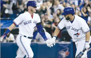  ??  ?? Toronto Blue Jays third baseman Josh Donaldson (20) celebrates his solo home run with teammate Kendrys Morales during first inning MLB baseball action against the Tampa Bay Rays, in Toronto last August. Rogers Communicat­ions Inc. is reportedly...