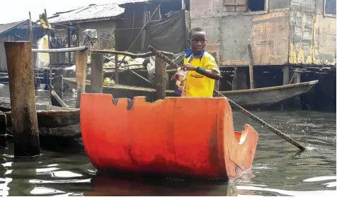  ?? Foto: dpa ?? Ein nigerianis­cher Schüler fährt mit einem improvisie­rten Kanu in Makoko nahe der Hafenstadt Lagos zu einer schwimmend­en Schule, die mithilfe von Geldern aus dem Ent wicklungsp­rogramm UNDP der Vereinten Nationen errichtet wurde.
