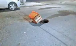  ?? /Víctor Cruz ?? Una caja y un palo son los que alertan del socavón sobre el asfalto.