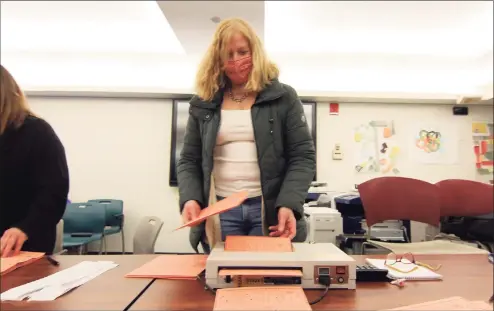  ?? Christian Abraham / Hearst Connecticu­t Media ?? Volunteer Michele Abbot runs absentee ballots through a tabulator as counting is done at the Government Center in Stamford on Tuesday.