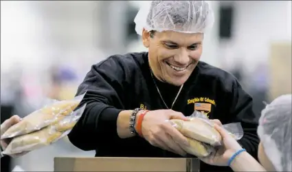  ?? Pam Panchak/Post-Gazette ?? B.J. Osso of McKees Rocks boxes up packaged fortified macaroni and cheese packets Friday during Amen to Action 2017 at the David L. Lawrence Convention Center in Pittsburgh.