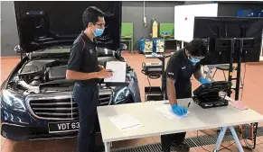  ??  ?? Learning the ropes: A certified Mercedes-Benz trainer assessing a student under the apprentice­ship programme.