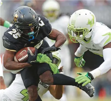  ?? FOOTBALL UCF AT USF CHASITY MAYNARD/ORLANDO SENTINEL ?? UCF running back Johnny Richardson ran for almost 100 yards in the 2021 version of the “War on I-4” against USF.