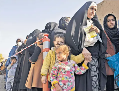  ?? ?? Long lines form as Afghans queue for basic food aid in Kabul where hospitals are struggling to cope with the number of children suffering from malnutriti­on