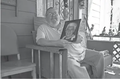  ?? JOHN BAZEMORE/AP ?? James Kelly shows a photo of his late father, also named James Kelly, at his Atlanta home. Kelly had to delay his plans to travel to Scotland, where he planned to scatter his father’s ashes.