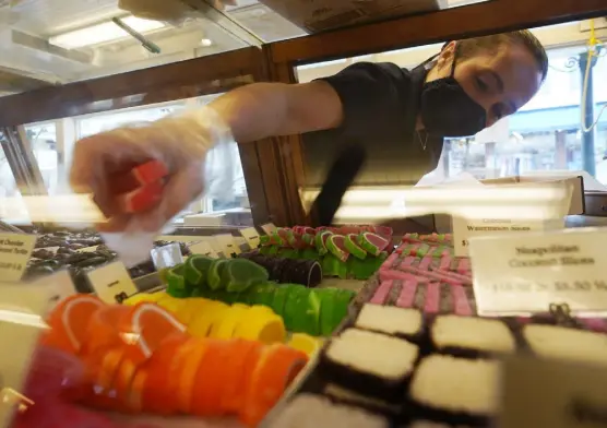  ?? Robert F. Bukaty, The Associated Press ?? Beth Duckworth fills a display cabinet with sweet treats at The Goldenrod, a popular restaurant and candy shop Wednesday in York Beach, Maine.