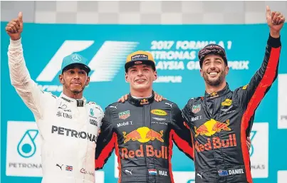  ?? Picture: Getty. ?? Max Verstappen, centre, Lewis Hamilton, left, and Daniel Ricciardo celebrate on the podium after the Malaysian Grand Prix.
