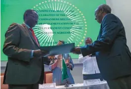  ?? BRIAN INGANGA/AP ?? Ethiopian Armed Forces Field Marshall Birhanu Jula, left, and chief Tigray Forces Lt. Gen. Tadesse Werede, right, exchange copies of an agreement on Saturday.