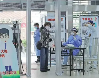  ?? YIN LIQIN / CHINA NEWS SERVICE ?? A nurse directs a patient for further treatment at a community health center in Shanghai earlier this month.