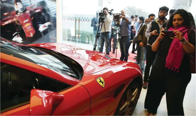  ??  ?? NEW DELHI: Indian media photograph a Ferrari California at the opening of the Ferrari showroom in New Delhi yesterday. The new showroom becomes Ferrari’s only official dealership in New Delhi and signals the Italian sport car brand’s ambition to expand...