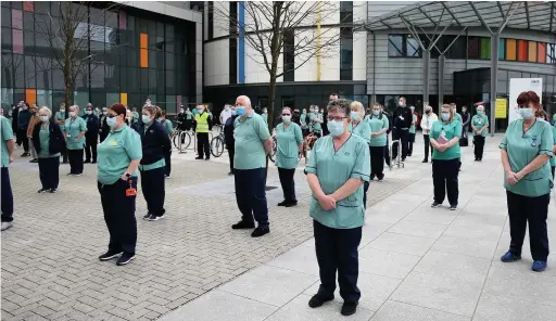  ??  ?? Staff observe a minute’s silence outside the Queen Elizabeth University Hospital in Glasgow to remember the victims of coronaviru­s