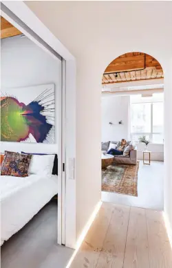  ??  ?? Led-lit Douglas fir flooring from Dinesen paves the way from living room to master suite. Painting above CB2 bed by Callen Schaub.