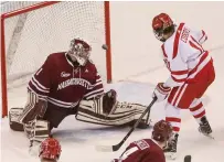  ?? STAFF PHOTOS BY NICOLAUS CZARNECKI ?? CHECK THIS OUT: BU’s Patrick Curry and UMass goalie Ryan Wischow watch the puck nearly go in for a Terriers goal during last night’s game at Agganis Arena.