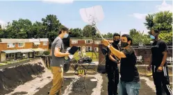  ?? JARED SOARES/NEW YORK TIMES FILE PHOTO ?? Adam Bouhmad, second from right, and his team set up an antenna for internet access on the roof of a home in Baltimore on June 18.