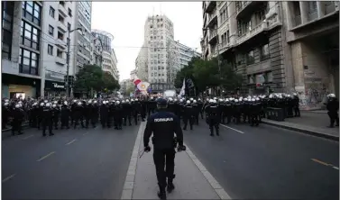  ?? (AP/Darko Vojinovic) ?? Serbian police officers stand ready Saturday as demonstrat­ors take the streets in Belgrade to protest potential new coronaviru­s restrictio­ns announced by the government.