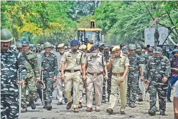  ?? — PTI ?? Police and security personnel arrive with a bulldozer ahead of an anti-encroachme­nt drive by the MCD, at New Friends Colony in New Delhi on Tuesday.