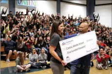  ?? Christina Cox/ The Signal (See additional photos at signalscv.com) ?? From left to right, local Farmers Insurance agent Christine Gonzales and Castaic Middle School TV Teacher Ro Osano cheer as they hold up a $100,000 national grant from Farmers Insurance that was awarded to the school on Monday. They were one of five...