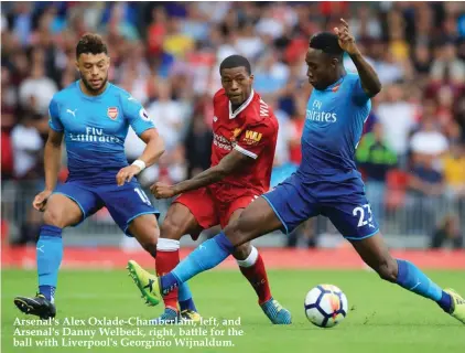  ??  ?? Arsenal's Alex Oxlade-Chamberlai­n, left, and Arsenal's Danny Welbeck, right, battle for the ball with Liverpool's Georginio Wijnaldum.