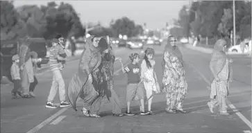  ?? Photograph­s by Irfan Khan Los Angeles Times ?? WOMEN and children head to Gurdwara Guru Angad Darbar, a Sikh house of worship in Bakersfiel­d. Sikh advocates say President Trump’s immigratio­n and travel orders correlate with an uptick in anti-Sikh crimes.