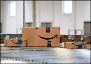  ?? BESS ADLER / BLOOMBERG ?? Packages move along a conveyor belt at an Amazon facility in Robbinsvil­le, N.J. Records show thousands of Amazon employees rely on government aid.