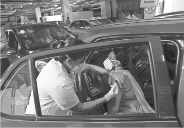  ?? RAJANISH KAKADE/AP ?? A woman receives a vaccine for COVID-19 in her car in Mumbai, India.