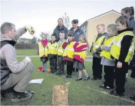  ??  ?? Plant ysgol lleol yn gwrando’n astud ar gyfarwyddi­adau Matt towe cyn plannu’r bylbiau