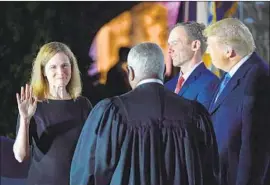  ?? Nicholas Kamm AFP/Getty Images ?? AMY CONEY BARRETT takes a constituti­onal oath Monday before, from left, Justice Clarence Thomas; President Trump; and her husband, Jesse M. Barrett.