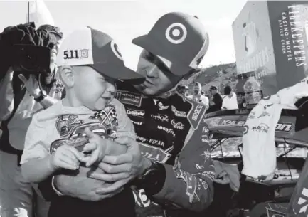  ??  ?? Kyle Larson celebrates with his son, Owen, in Victory Lane on Father’s Day after winning the NASCAR Cup race at Michigan Internatio­nal Speedway. Martin Truex Jr. of Denver-based Furniture Row Racing finished sixth. Jonathan Ferrey, Getty Images