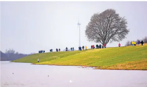  ?? RP-FOTO: CHRISTOPH REICHWEIN ?? Das Hochwasser lockt in diesen Tagen zahlreiche Schaulusti­ge an die Deiche und direkt bis ans Ufer.